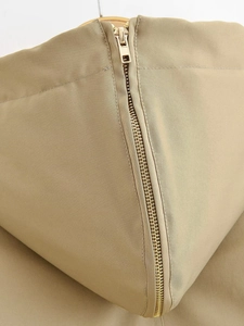 Primer plano de la cremallera dorada metálica en la chaqueta con capucha caqui de tela suave