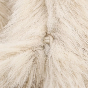 Detailed close-up of cream faux fur texture with a woven loop closure on the jacket