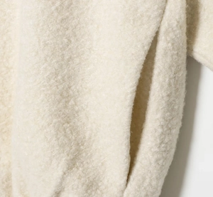 Close-up of side pocket and soft sherpa fleece texture on a beige stand collar jacket