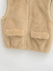 Détail de gilet en fausse fourrure beige avec texture douce et fermeture éclair métal