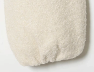 Close-up of cream faux shearling jacket showing the soft textured fabric and elastic cuff