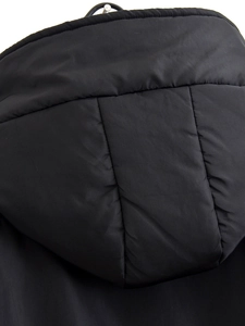 Gros plan sur le détail d'une doudoune noire matelassée avec des coutures de qualité
