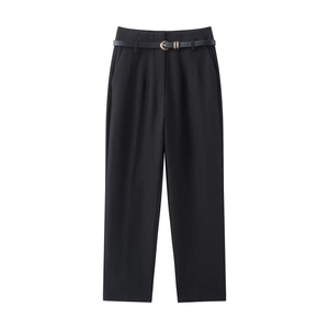 Détail d'un pantalon noir taille haute avec ceinture fine et boucle en métal doré