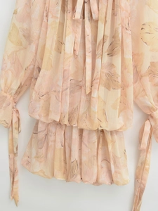 Detail view of floral chiffon top with drawstring sleeves and elastic pleated hemline