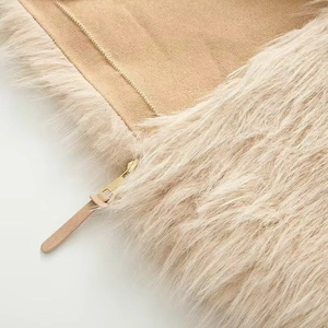 Close-up of beige faux fur jacket featuring camel suede panels and gold metal zipper detail