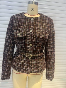 Detail of tweed texture and metallic buttons on pink mixed fiber jacket with belt