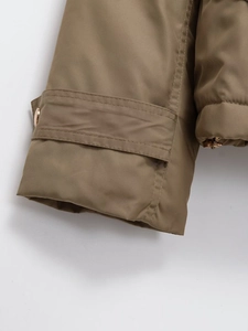 Detailed close-up of khaki twill jacket sleeve with adjustable cuff and gold button