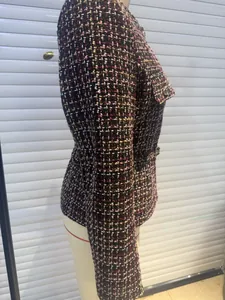 Close-up of pink and brown tweed jacket texture with golden thread and metal button