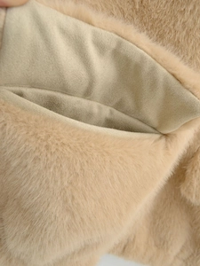 Gros plan détaillé de la texture en fausse fourrure et de la doublure d'un gilet beige