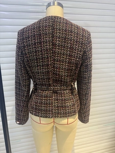 Rear view of women's tweed jacket showing intricate purple weave and waist tab detail