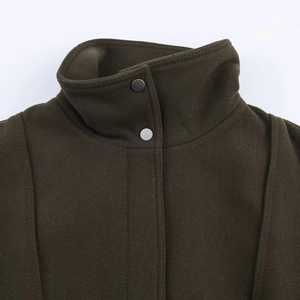 Detail of high stand collar and silver metal buttons on dark green wool jacket