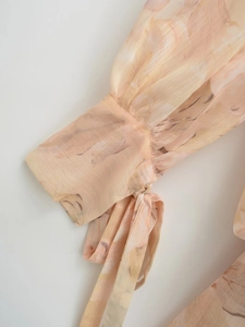 Detail of floral print chiffon cuff featuring an elegant adjustable bow tie closure