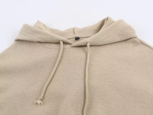 Detail of khaki ribbed knit hoodie showing the drawstring and fabric texture close-up