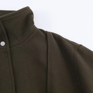Detail of olive wool jacket showing stand collar, metal button and shoulder stitching