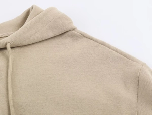Detail of premium beige hoodie showing thick cotton fabric texture and hood drawstring