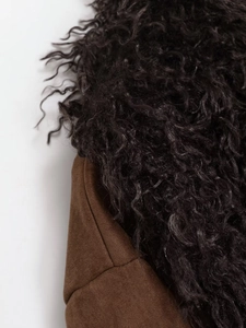 Detailed view of dark brown faux suede texture and curly black faux fur lining on jacket