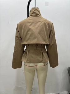 Rear view of khaki short trench coat featuring back storm flap and adjustable waist belt