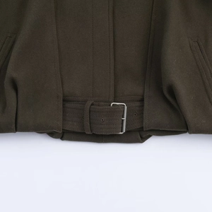 Detailed view of dark olive jacket hem with thick wool fabric and silver metal buckle