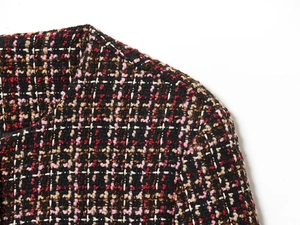 Close-up of multicolored tweed fabric texture with black and pink woven fibers