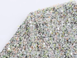Détail du tissu en tweed multicolore avec fils vibrants et accents de paillettes argent