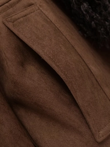 Detail view of brown faux suede jacket with pocket stitching and black faux fur trim
