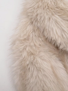 Close-up of soft beige faux fur texture on long-sleeve winter jacket for women