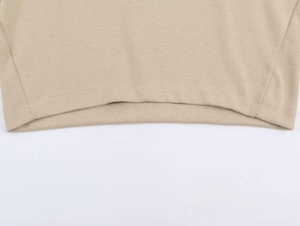 Detailed close-up of the fine knit texture and flat hem stitching on this beige tracksuit