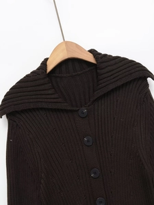 Vue détaillée du gilet en maille côtelée marron foncé avec grand revers et boutons noirs
