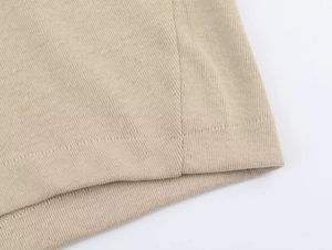 Detailed close-up showing clean stitching and premium knit texture on beige sweatsuit