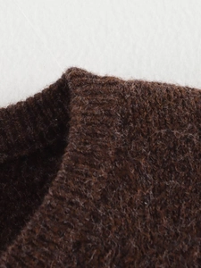 Gros plan sur la texture en maille marron foncé avec détails côtelés et fibres de laine