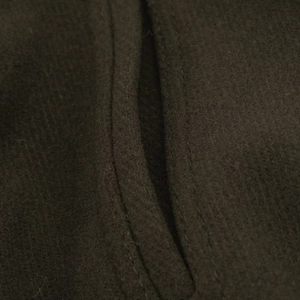 Detail of wool fabric texture and double-needle stitching on jacket pocket edge