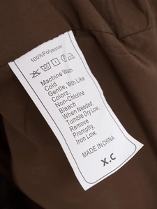 Close-up of internal wash care label showing 100% polyester material and washing icons