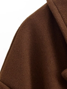 Dettaglio del colletto a rever e della cucitura della spalla su un cappotto di lana marrone
