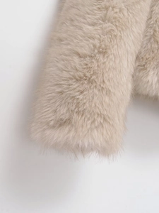 Detailed close-up of fluffy apricot faux fox fur texture on the jacket sleeve cuff