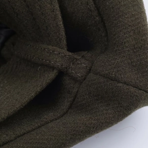 Detail of olive green wool jacket featuring premium double stitching and felt texture
