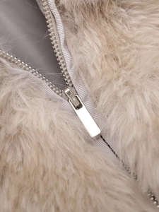 Macro view of fluffy faux fur texture with a premium silver metal zipper detail