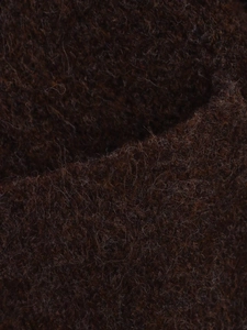 Gros plan sur la texture en tricot de laine mohair marron foncé à poils longs