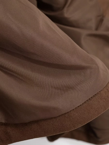 Detail view of smooth brown lining and faux suede fabric with precise stitching on jacket