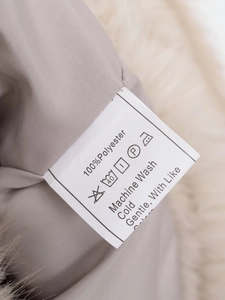 Detail of soft faux fur lining and garment care label showing 100% polyester material