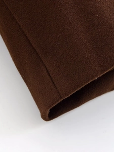 Dettaglio delle cuciture e della trama del tessuto del cappotto di lana marrone