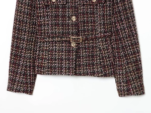 Detail of tweed jacket texture with golden buttons and a matching waist belt