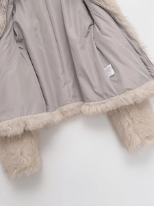 Detail view of smooth grey lining and laundry care label on faux fur jacket