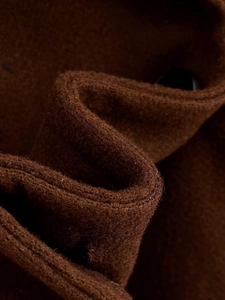 Vista macro che mostra la trama spessa e il tessuto lanoso del cappotto marrone scuro