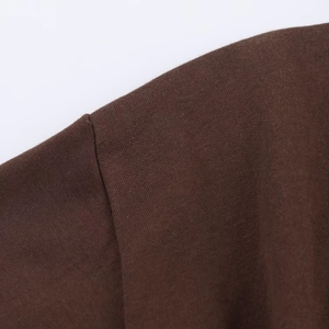 Vue détaillée des coutures d'épaule et de la texture en maille marron foncé de la veste