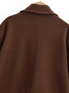 Dettaglio del retro di un cappotto di lana marrone scuro con colletto e cucitura centrale
