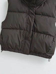 Detail of dark brown padded vest featuring adjustable drawstring hem and quilted fabric