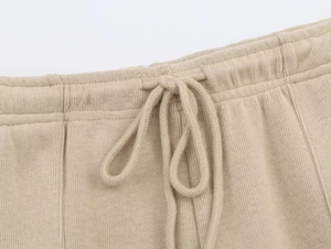 Detail shot of oatmeal ribbed knit waistband with a matching woven drawstring