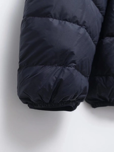 Detail of elastic windproof cuffs on a lightweight black puffer jacket with quilted fabric