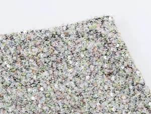 Vue détaillée du tissu en tweed multicolore avec des ornements de paillettes brillants