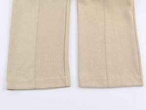 Detail of beige lounge pants showing smooth knit fabric texture and neat hem stitching